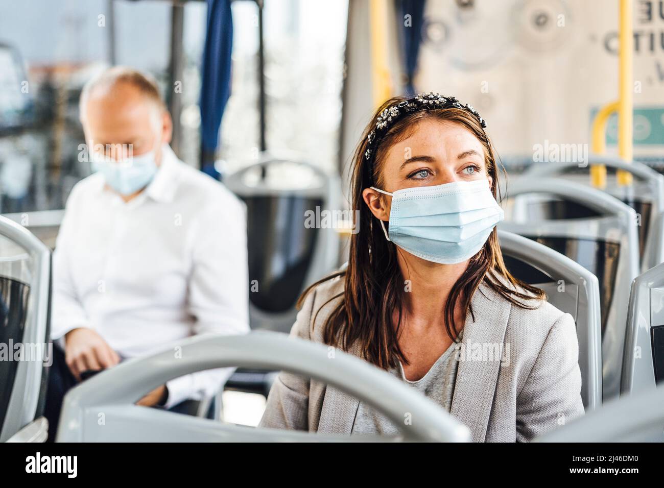 Travelers wearing protective masks commuting by public bus Stock Photo