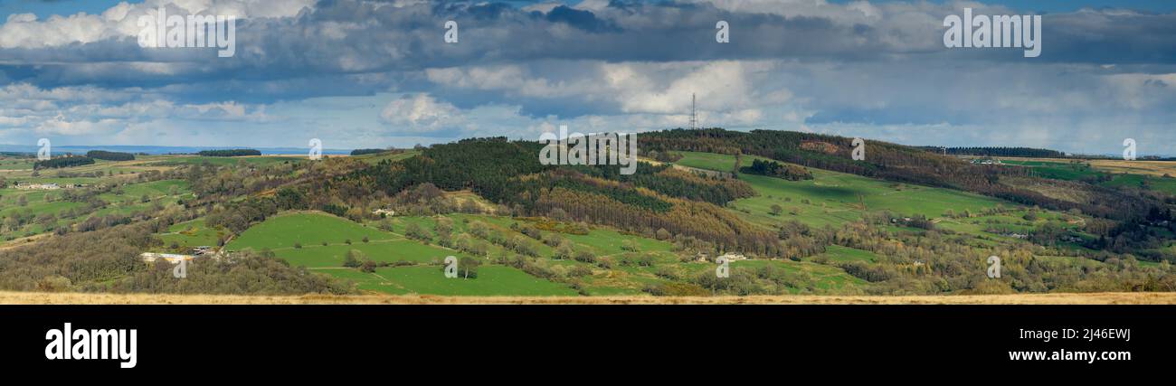 Long-distance picturesque sunny panorama (hillside woodland, green fields, tv radio mast tower, cloudy sky) - Washburn Valley, Yorkshire, England, UK. Stock Photo