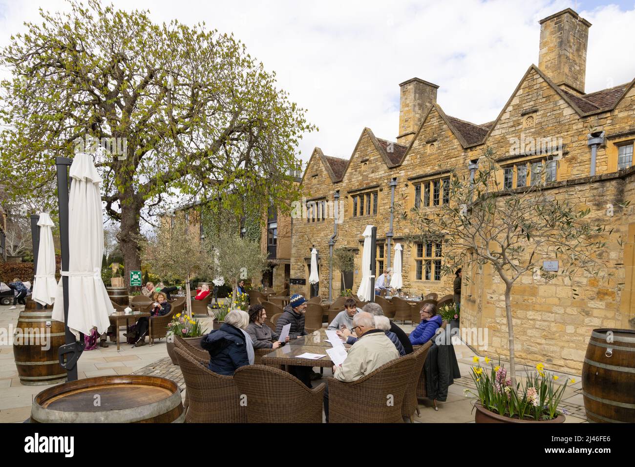 Cotswold Hotel; people sitting drinking in the courtyard of The Lygon Arms, a 14th century Hotel, Broadway Village, Cotswolds Worcestershire UK Stock Photo