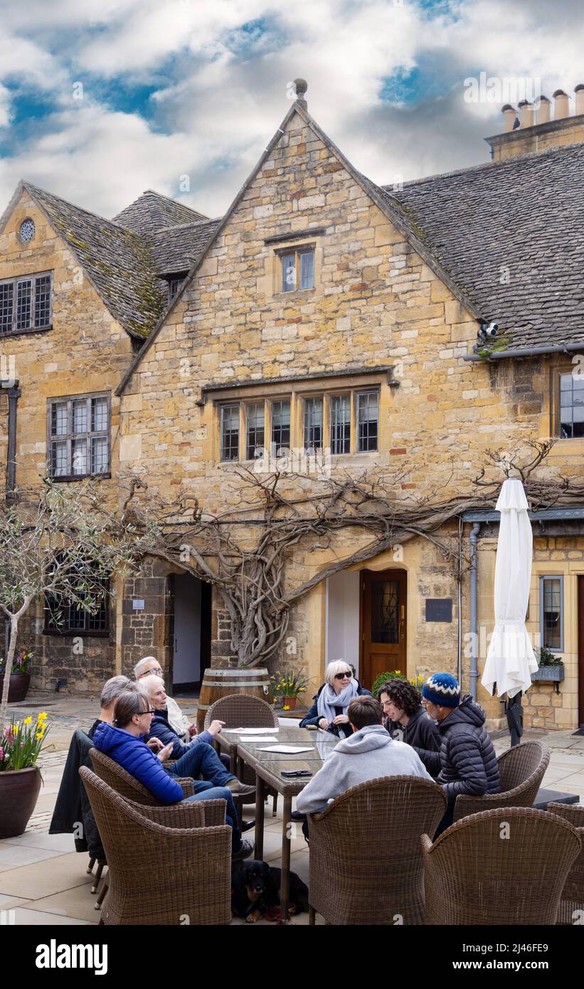 Cotswolds Hotel; people sitting drinking in the courtyard of The Lygon Arms, a 14th century Hotel, Broadway Village, Cotswolds Worcestershire UK Stock Photo