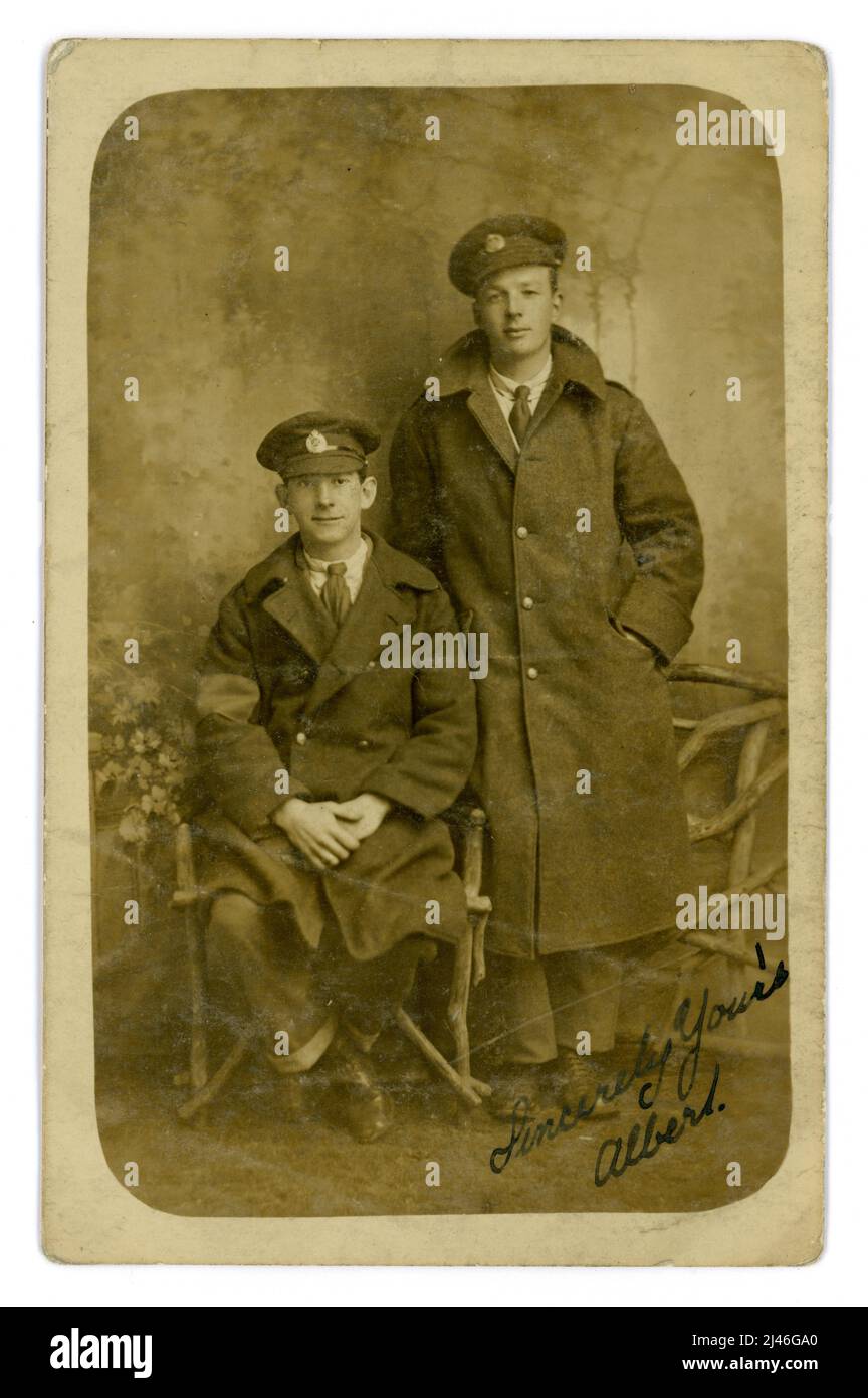 Original WW1 era postcard  of a pair of Royal Engineers, pals, their cap badges denote that they are both Royal engineers. They both wear greatcoats, one has visible arm band, denoting he has be wounded. They look happy enough to be invalided out of the war even temporarily. From the studio of Albert England, 60 High St. Barnet, London, England, U.K. 1914-1918 Stock Photo