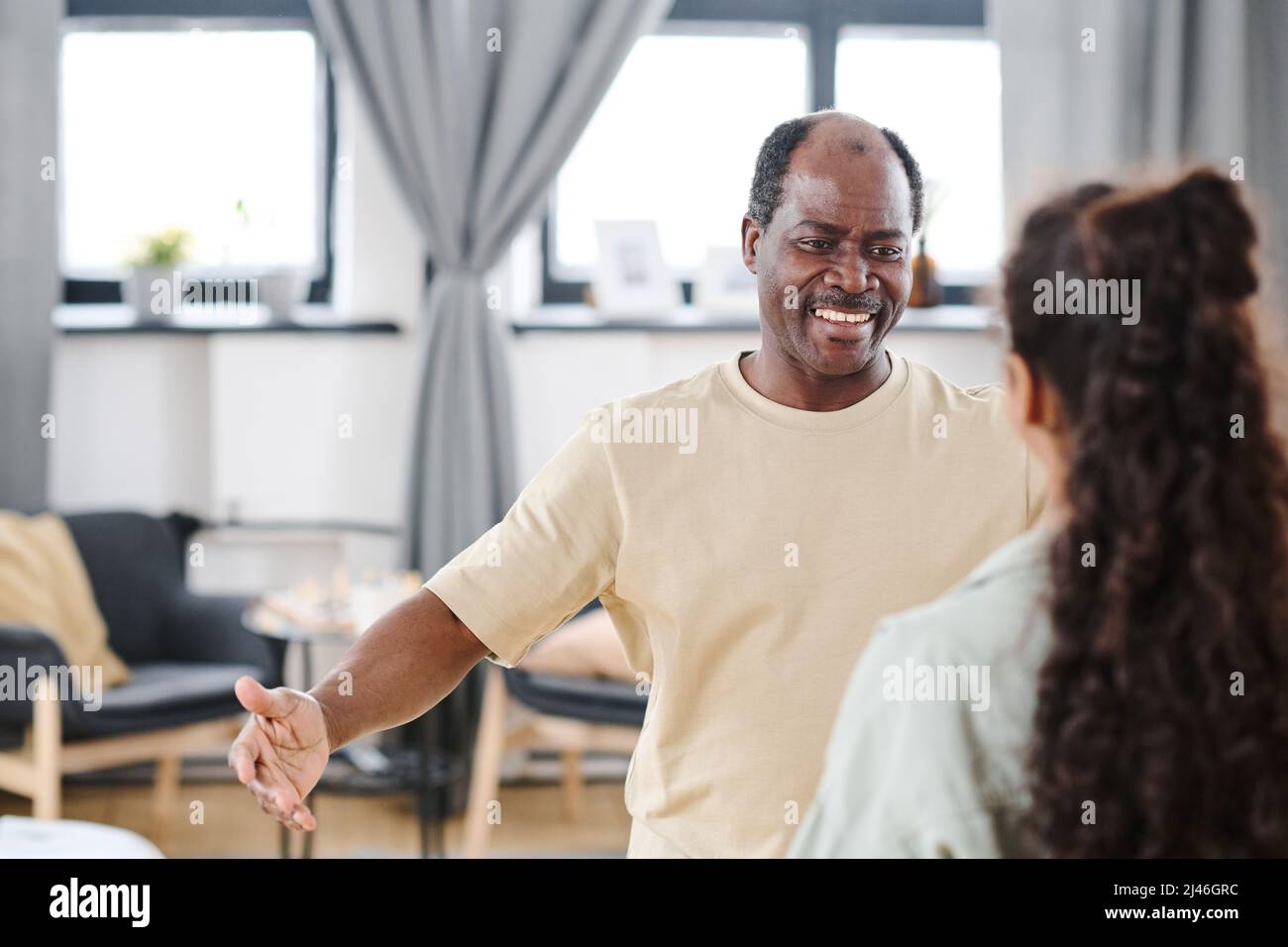 Contemporary senior black man with toothy smile giving hug to his ...