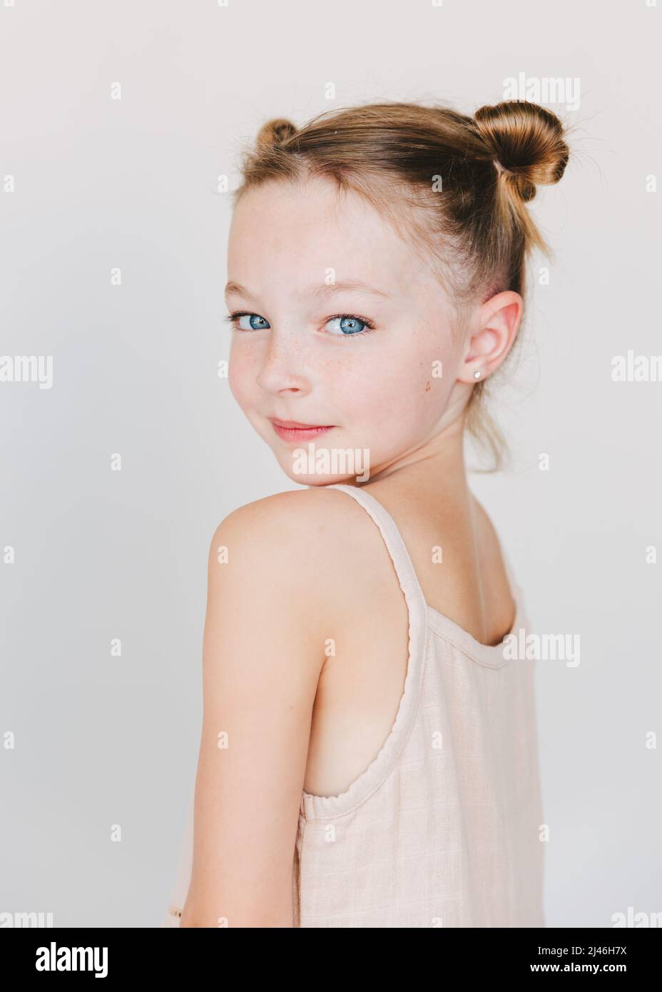 cute little girl looking over her shoulder, white background Stock
