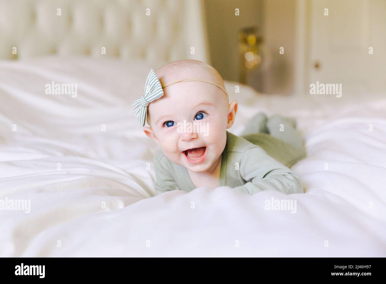 baby laying on her stomach on parents bed Stock Photo