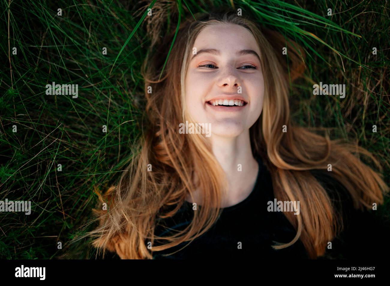 Happy woman lying on the grass smiling Stock Photo