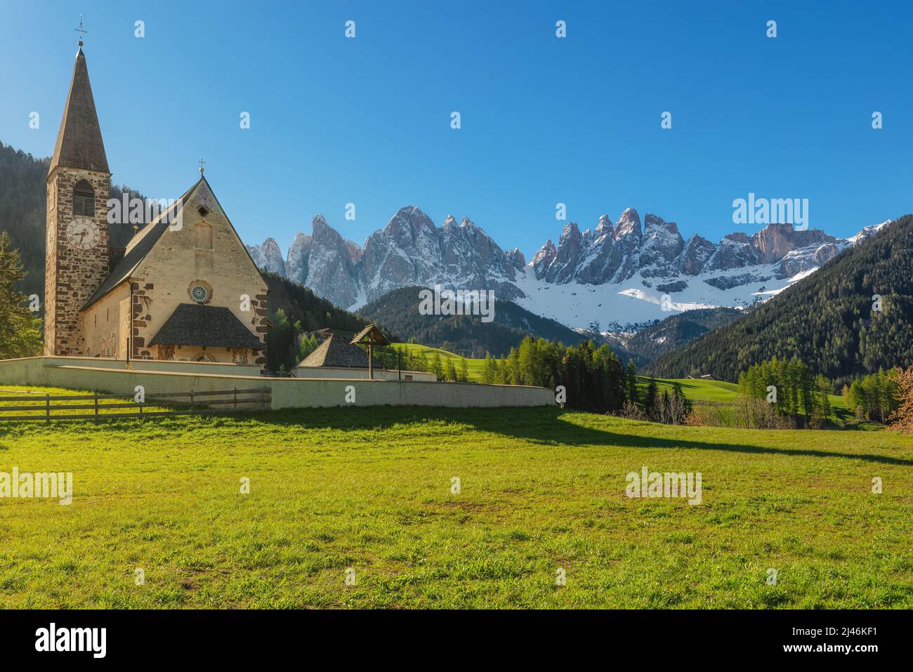 Santa Maddalena village with church and beautiful Dolomiti mountains, Val Di Funes, Dolomites, Italy in sunny morning. Travel destination Stock Photo