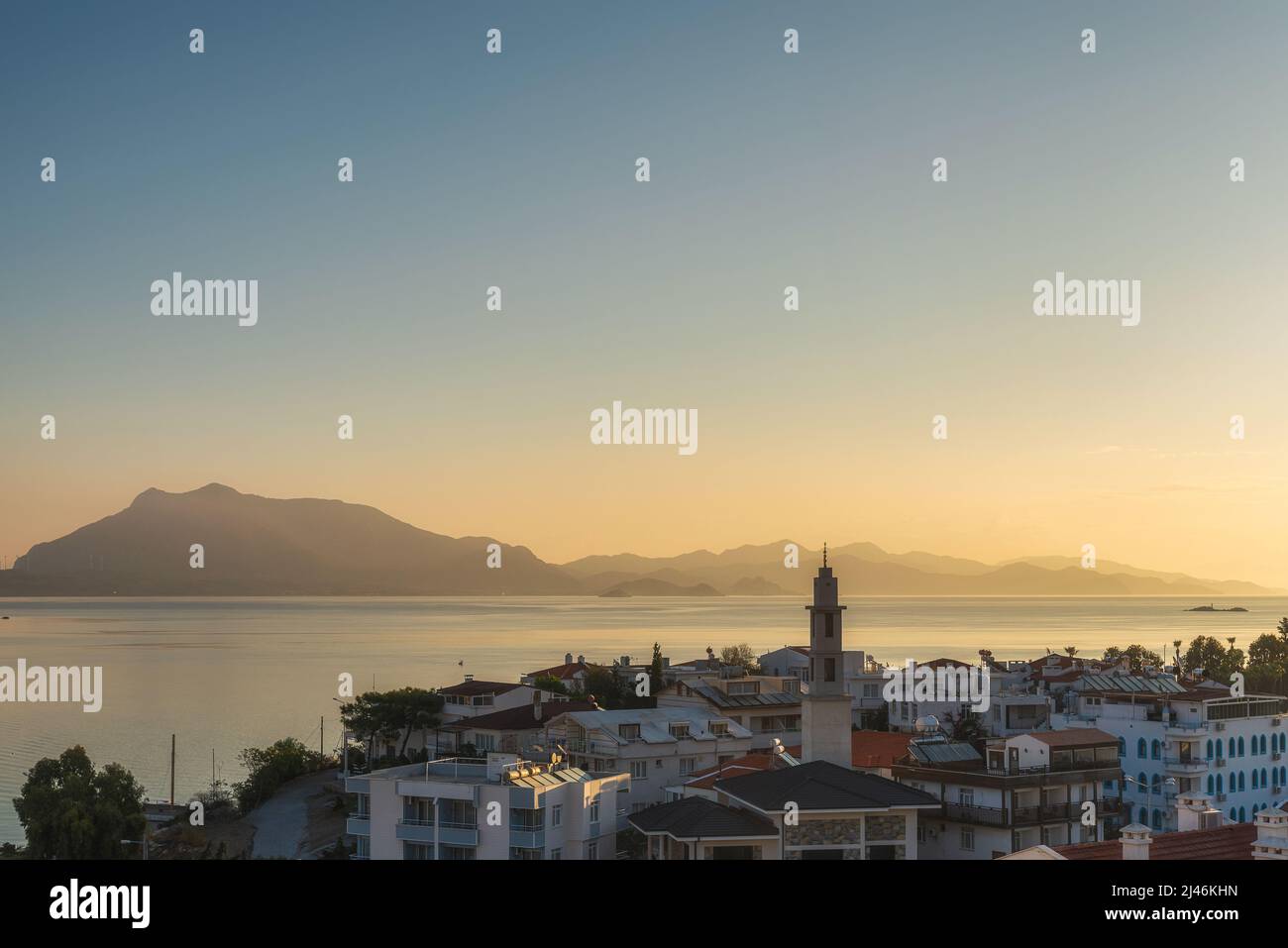 View on Datca town with harbor and island at sunrise, Mugla province, Turkey. Popular tourist summer destination in Turkey Stock Photo