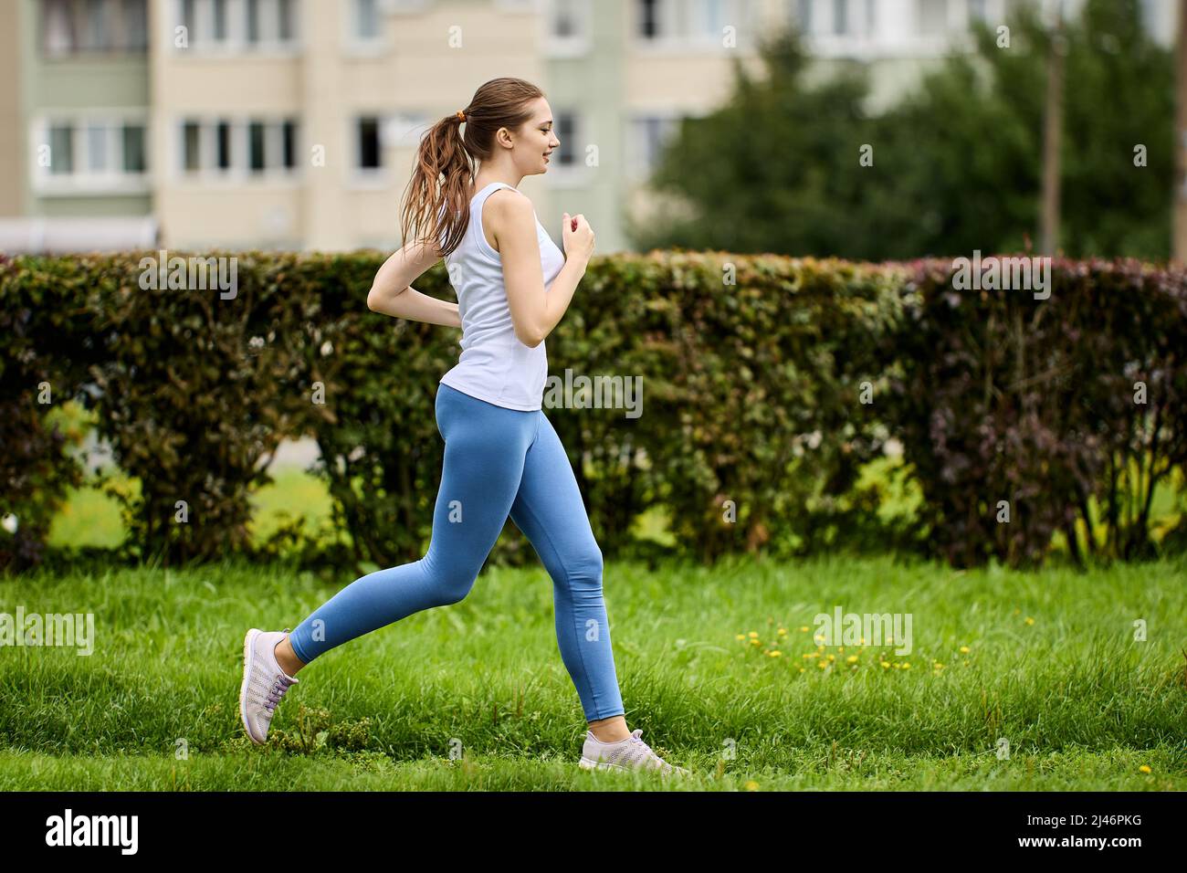 Jogging in city park in summer by slender woman 29 years old in leggins as  training outdoors Stock Photo - Alamy