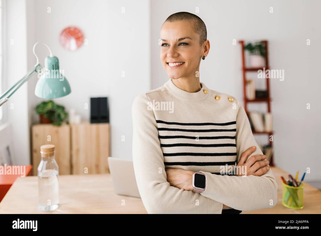 Thoughtful freelance woman standing in home office Stock Photo