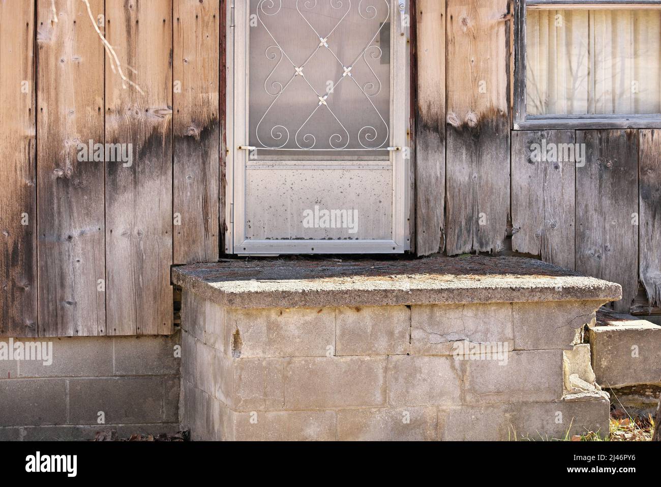 Close up of Weathered Wood Siding Beginning to Rot Around Front Step of Cottage or House Stock