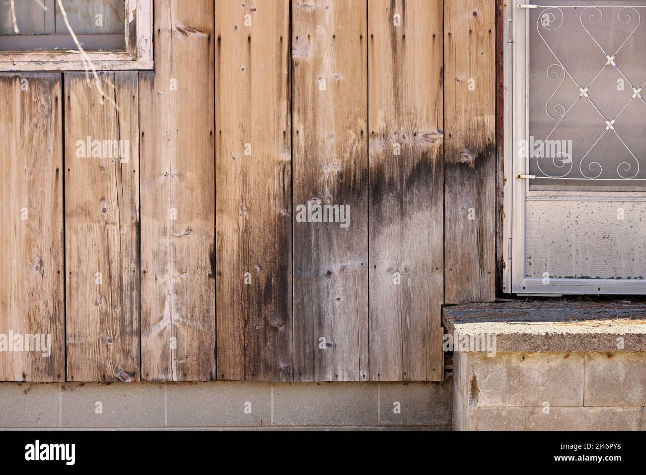 Close up of Weathered Wood Siding Beginning to Rot Around Front Step of