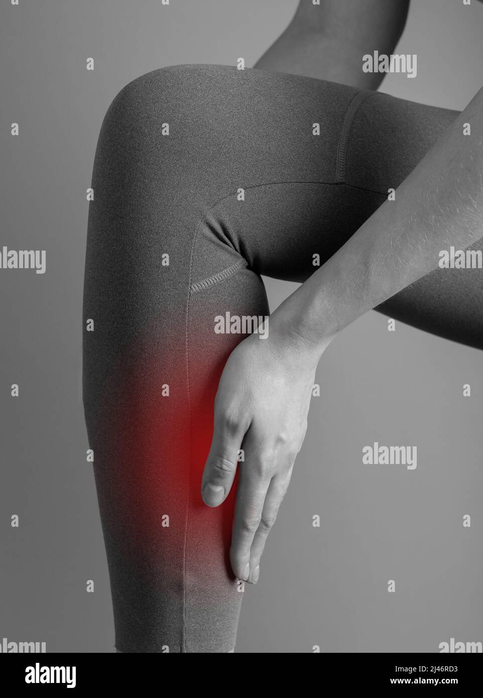 Shin splints. Woman holding painful leg with red point closeup. Muscles