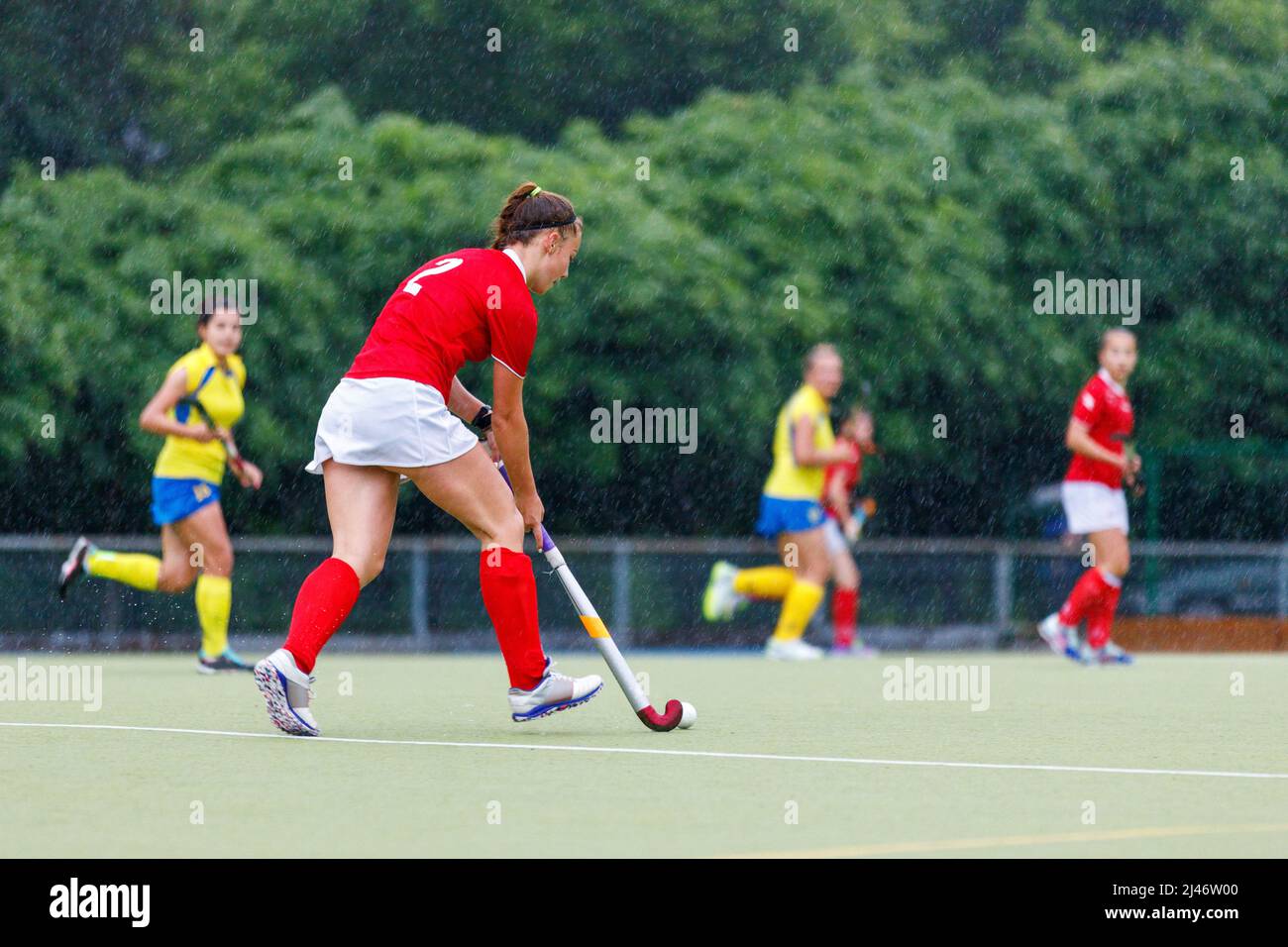 Young girl field hockey player running with the ball in attack Stock