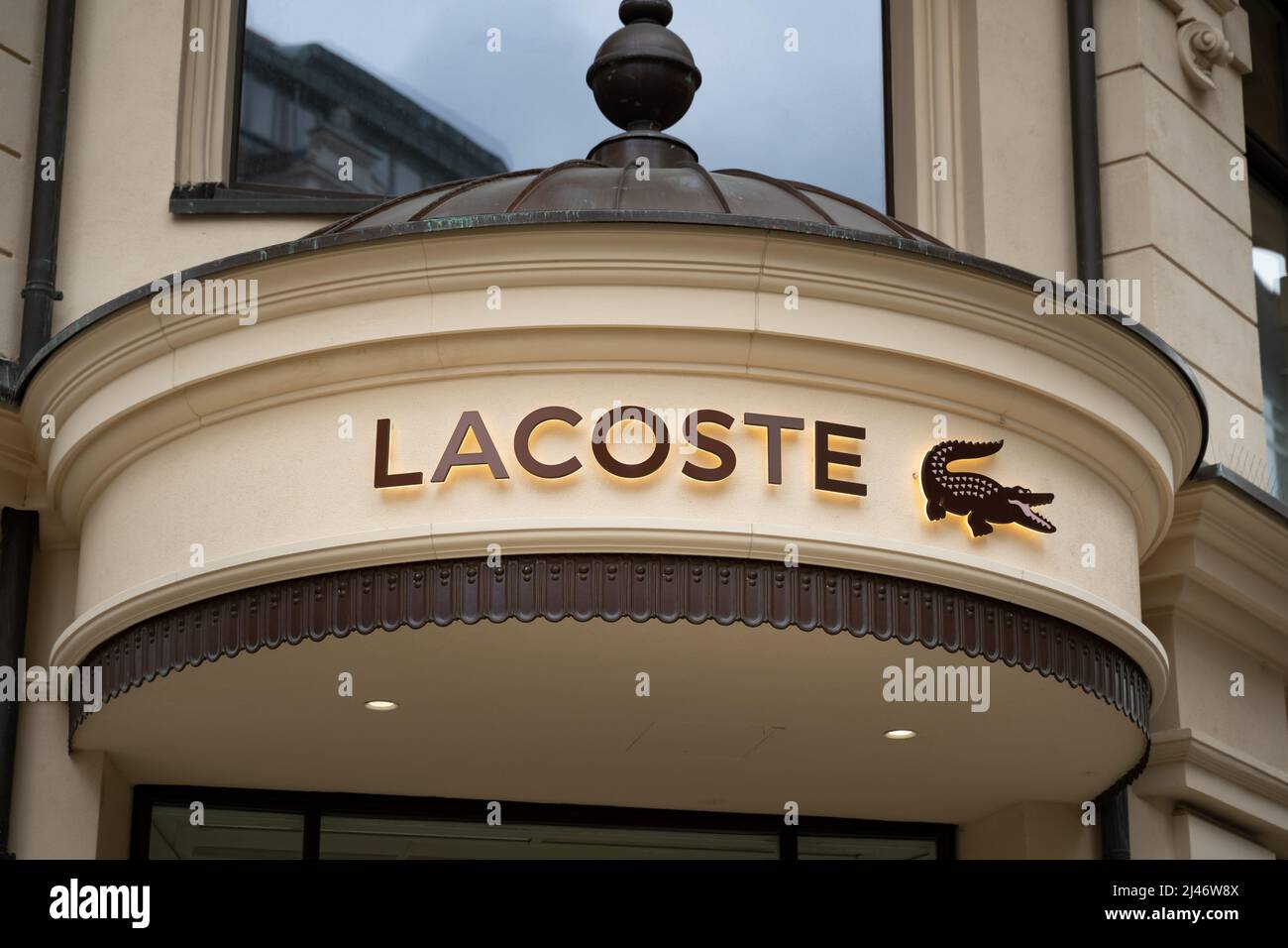 Lacoste lettering and logo on the facade of a building. Illuminated ...