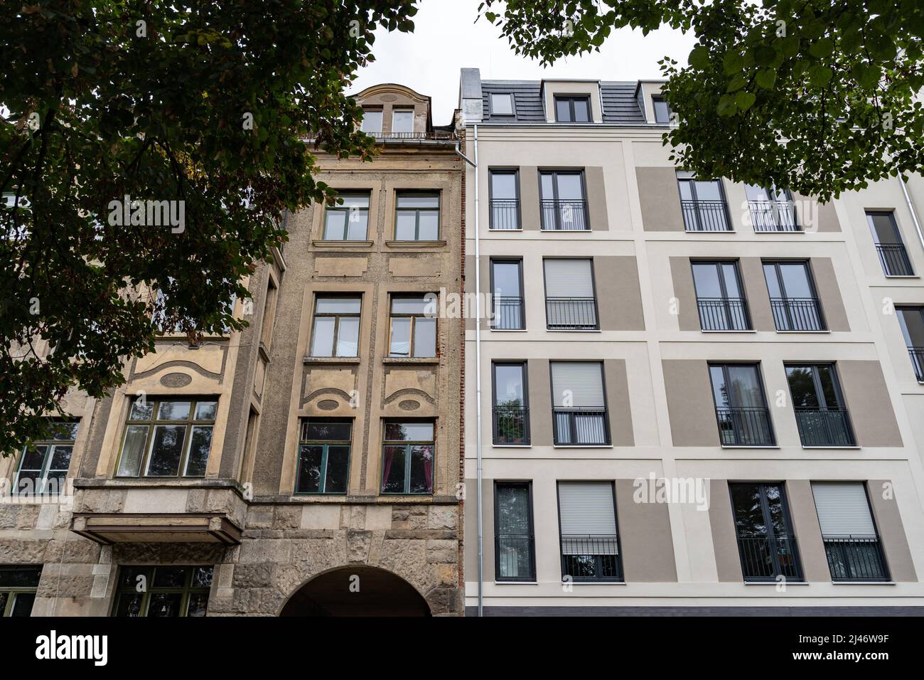 Facades of an old building next to a new building. Contrast in architecture styles of different eras. Historic and modern exteriors for an apartment. Stock Photo