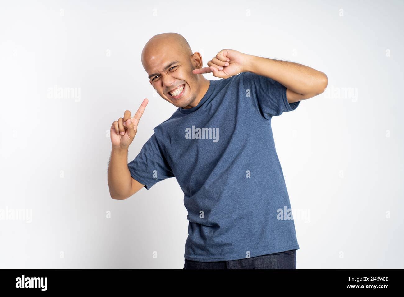 asian bald man laughing with finger gestures pointing cheek Stock Photo