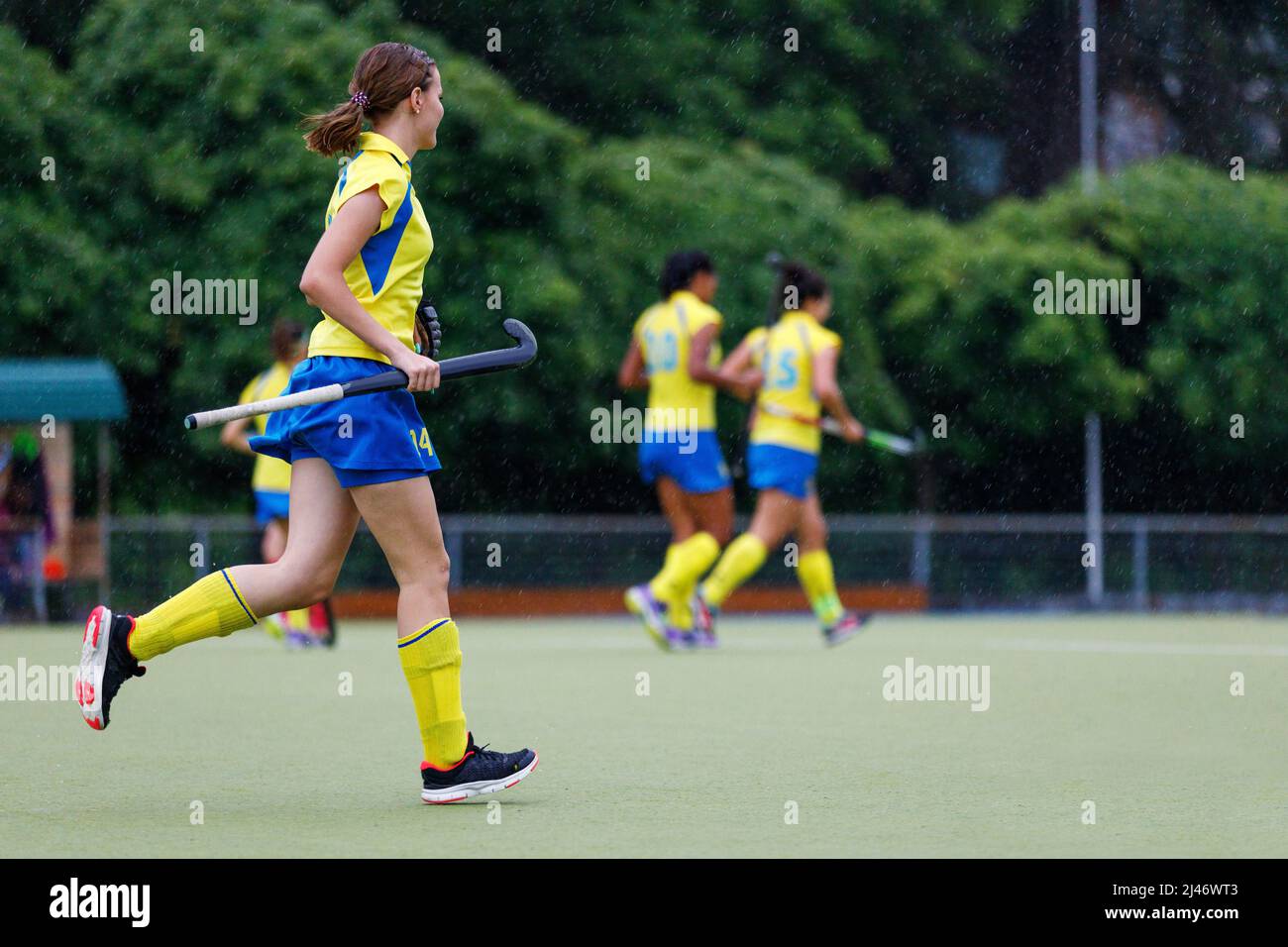 Young teenage girl running on the pitch during the field hockey game in