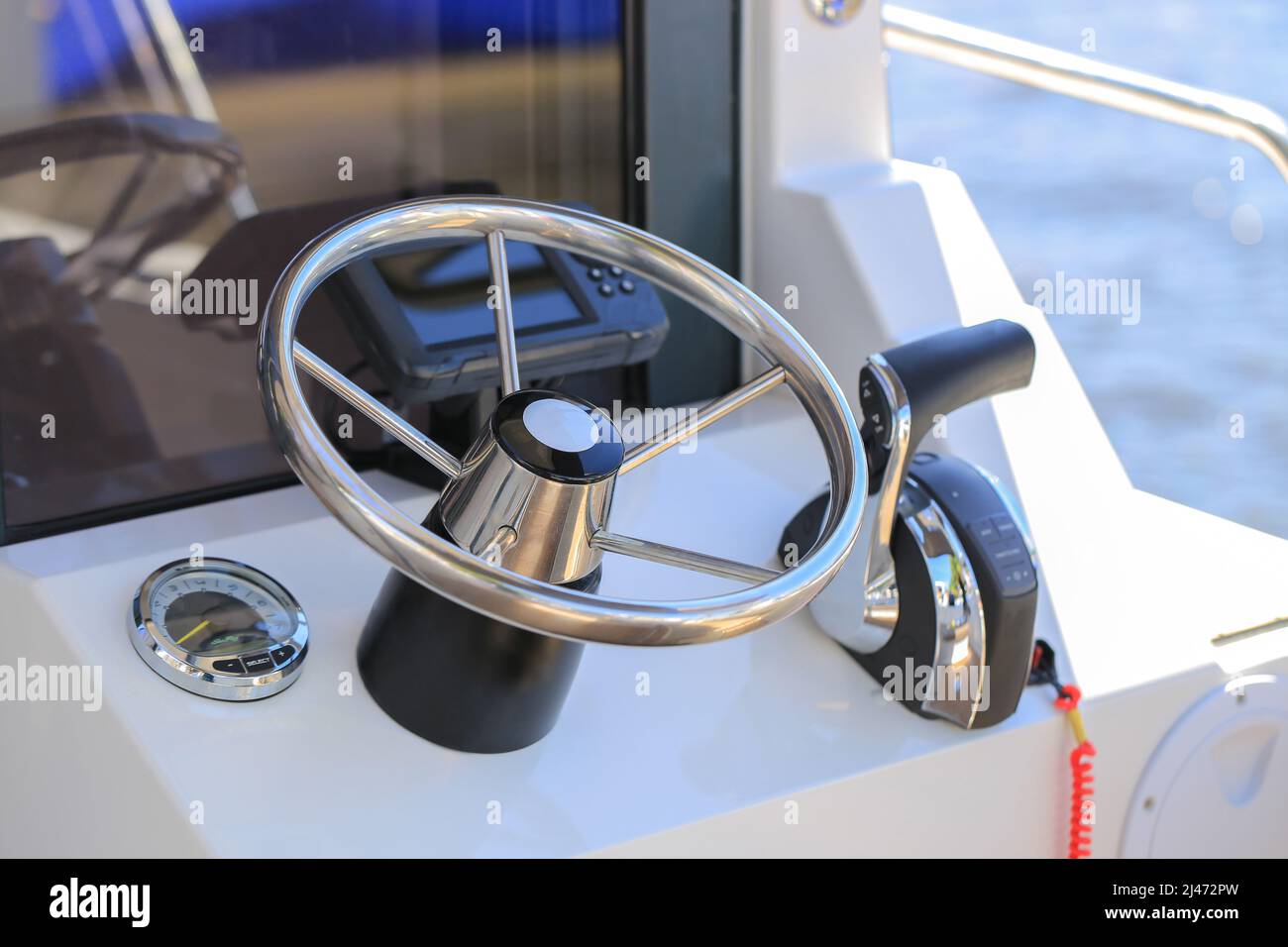 Motor boat steering wheel closeup and dashboard with navigation
