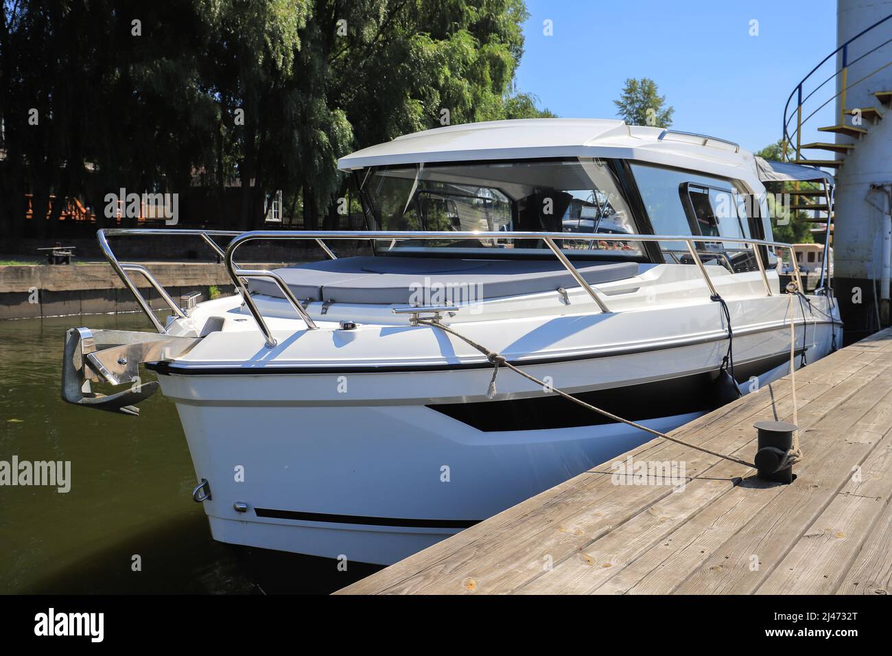 Motor boat moored near the pier in the harbor Stock Photo - Alamy