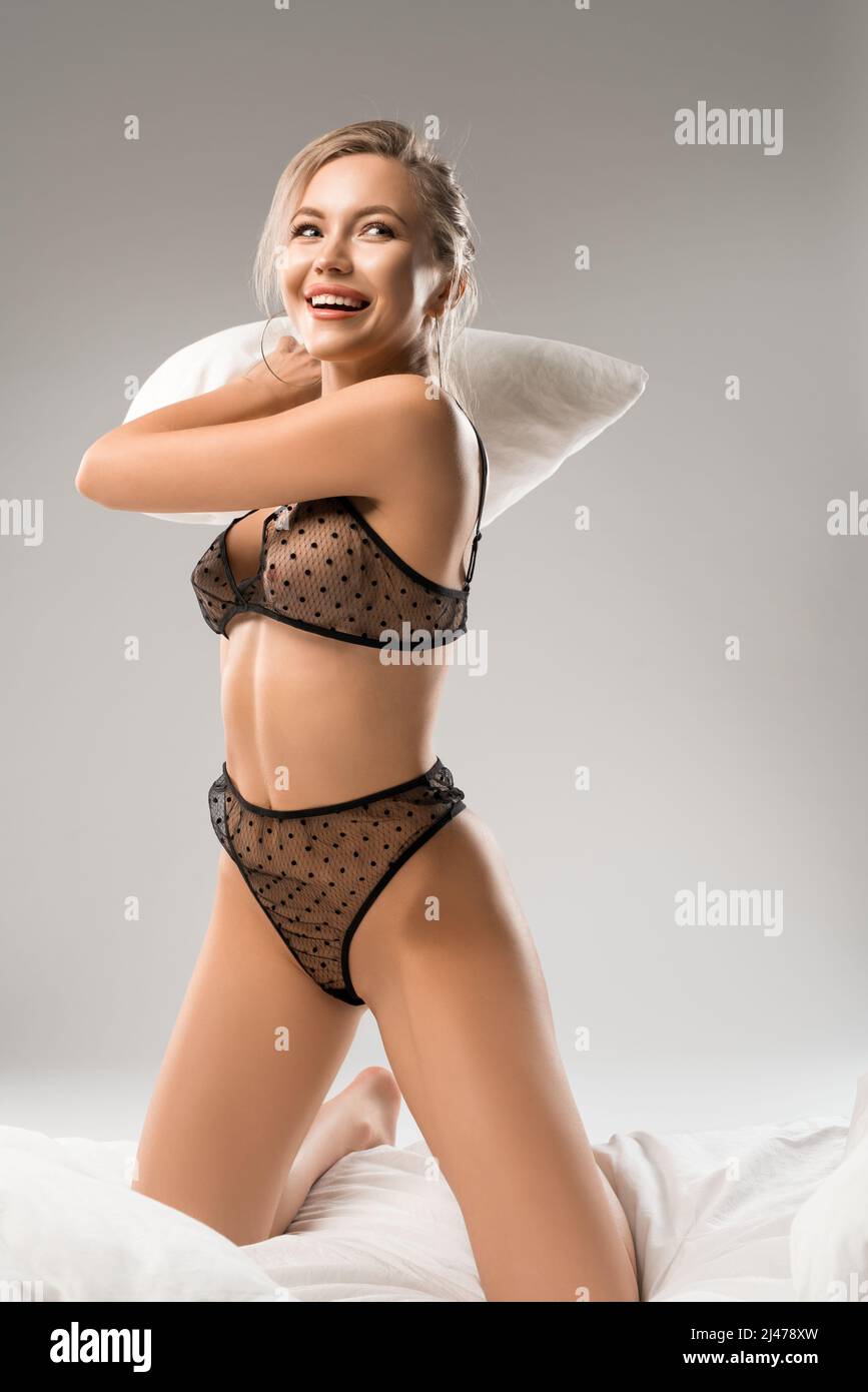 Flirty woman in sexy underwear fighting with pillow Stock Photo