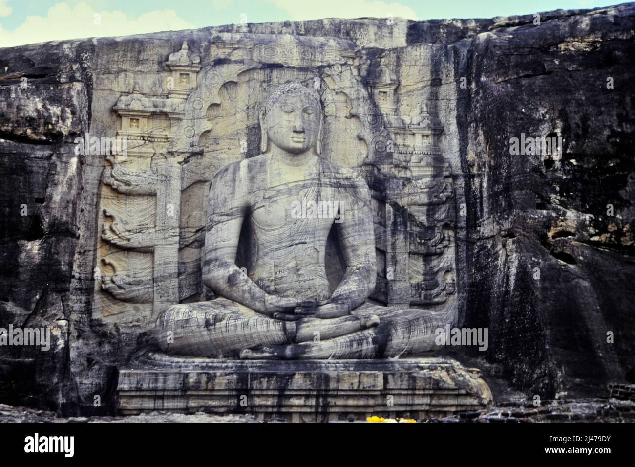 closeup of huge Buddha carving on stone wall in India Stock Photo
