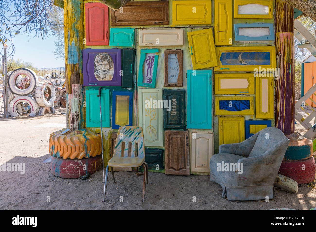 A decorated small building with painted cabinet doors and chairs in the settlement of East Jesus, California. Stock Photo