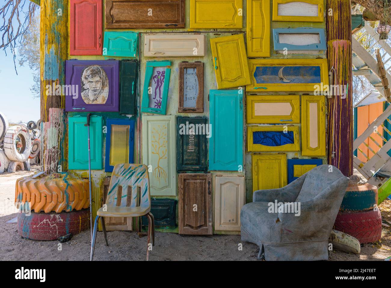 A decorated small building with painted cabinet doors and chairs in the settlement of East Jesus, California. Stock Photo