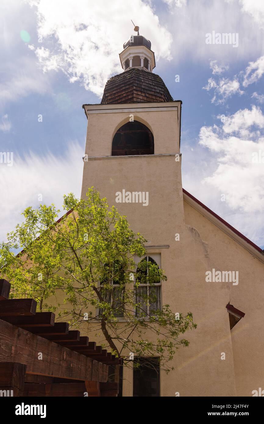 Front of Church with Bell Tower and Tree Stock Photo