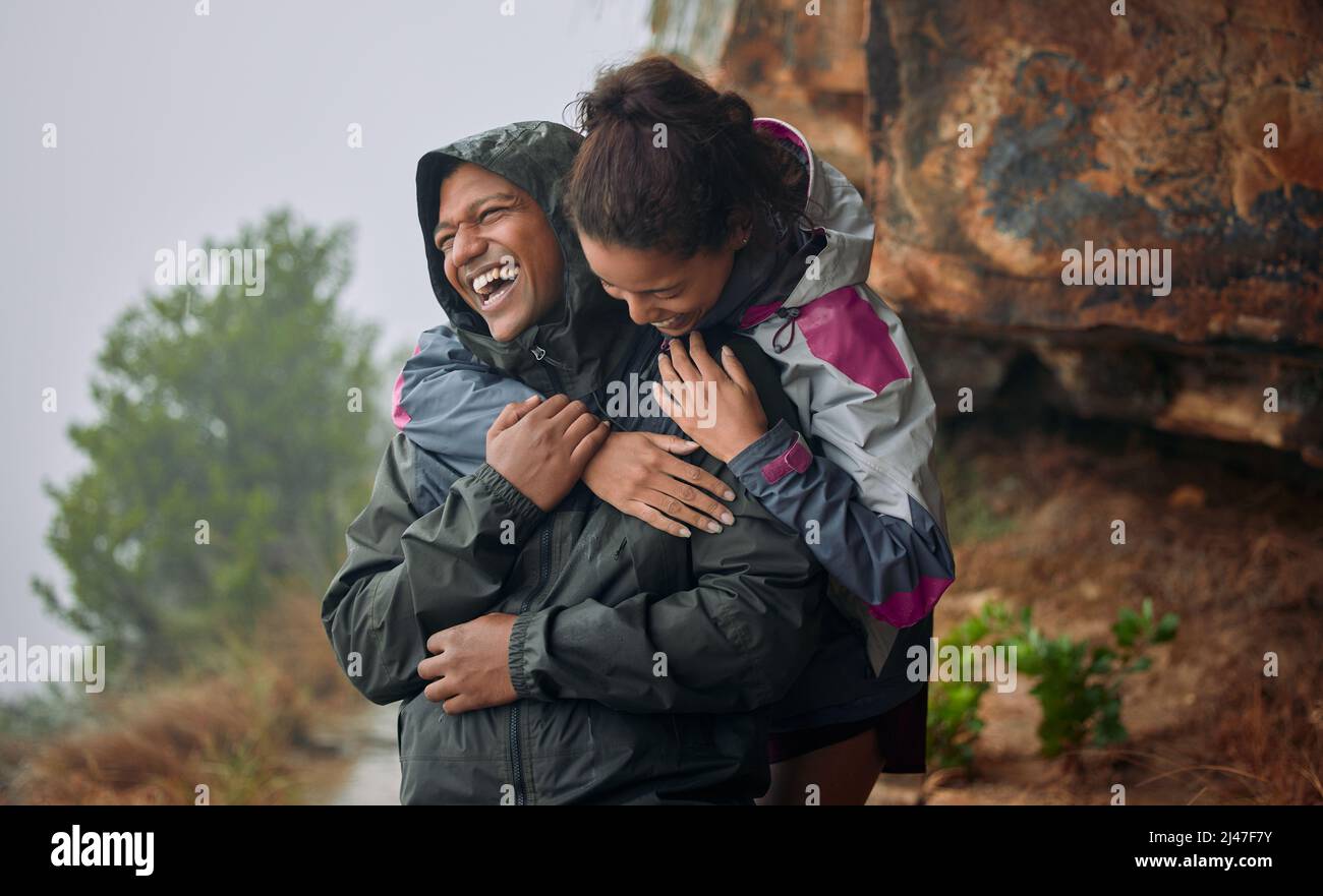 No one could ever make me feel the way you do. Shot of a young couple wearing their rain jackets while out hiking. Stock Photo
