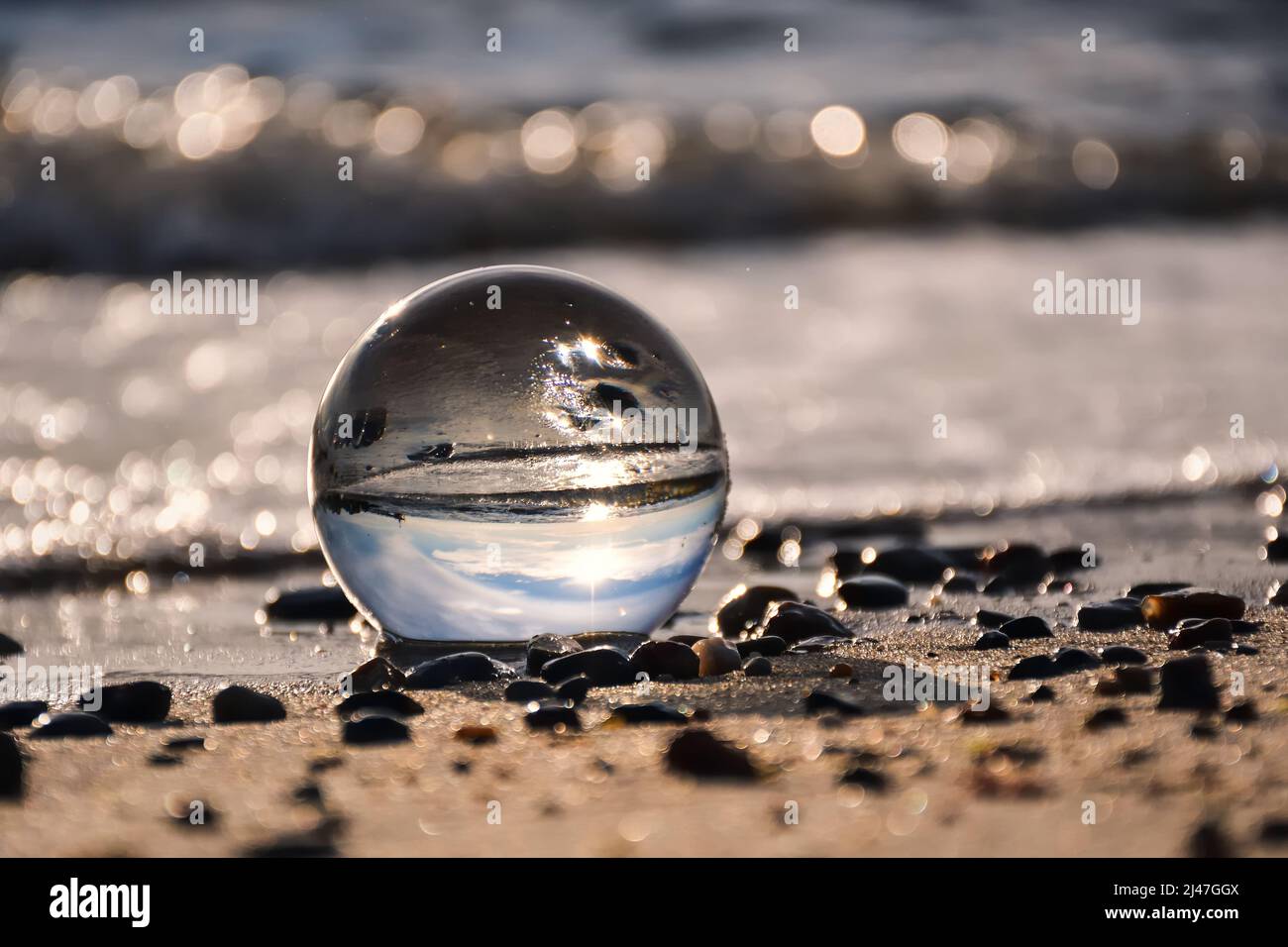 Abstract holiday seaside idea. Sea landscape held in a glass ball with a blurred background. Stock Photo
