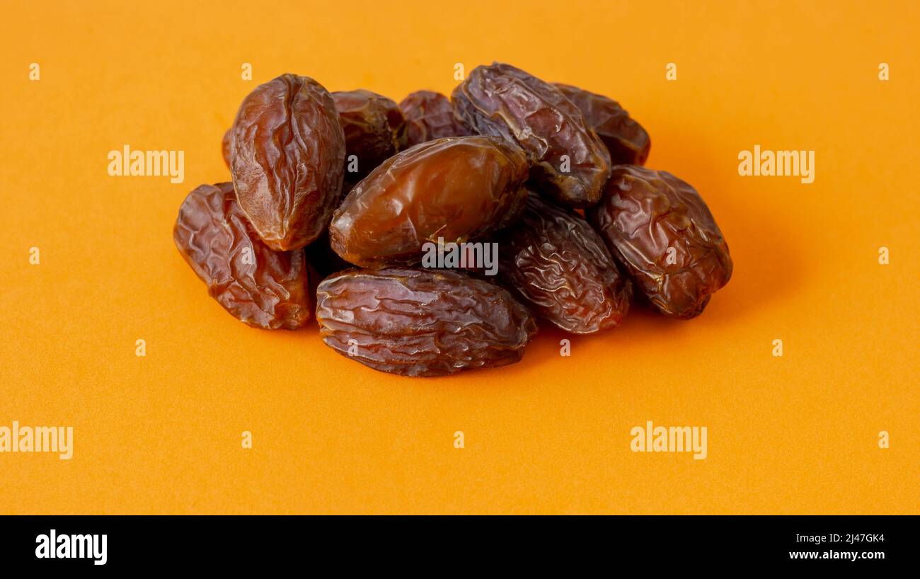 Pile of date fruit isolated on yellow background Stock Photo