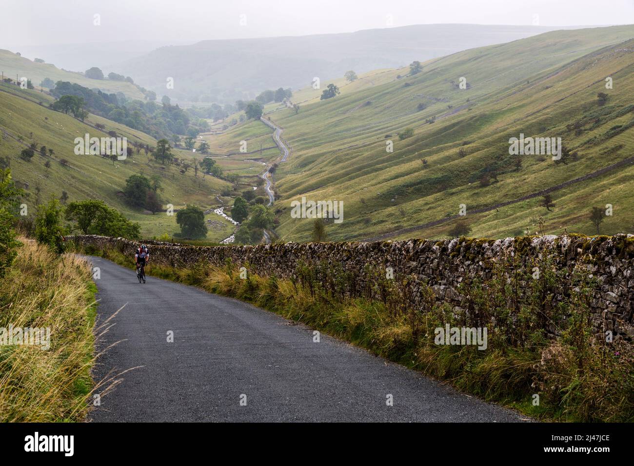 UK, England. Bicycle Rider Climbing Steep Hill on an Autumn Day in the