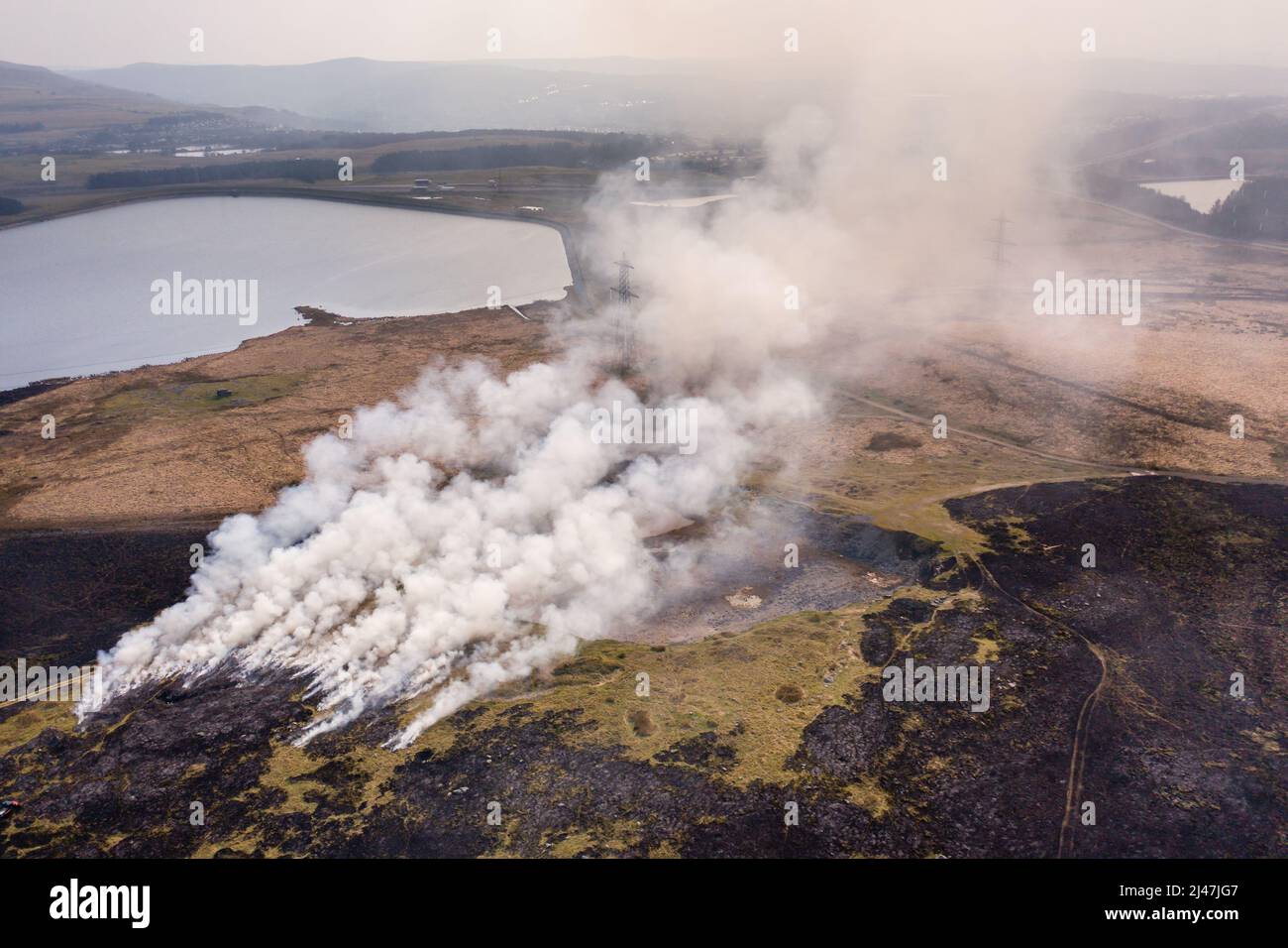 Aerial view of a huge wildfire on higher level moorland next to a reservoir (Llangynidr Moors, Wales) Stock Photo