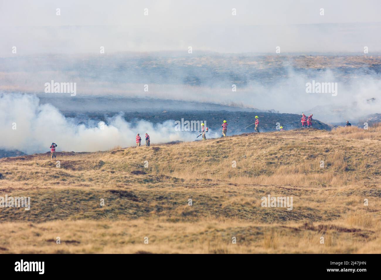 Fire fighters dealing with a large grassfire on an upland moors in Wales Stock Photo