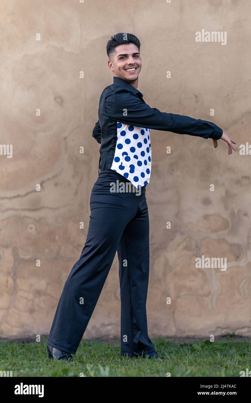 full-length portrait of a smiling flamenco dancer dressed in black with a polka-dotted waistcoat Stock Photo