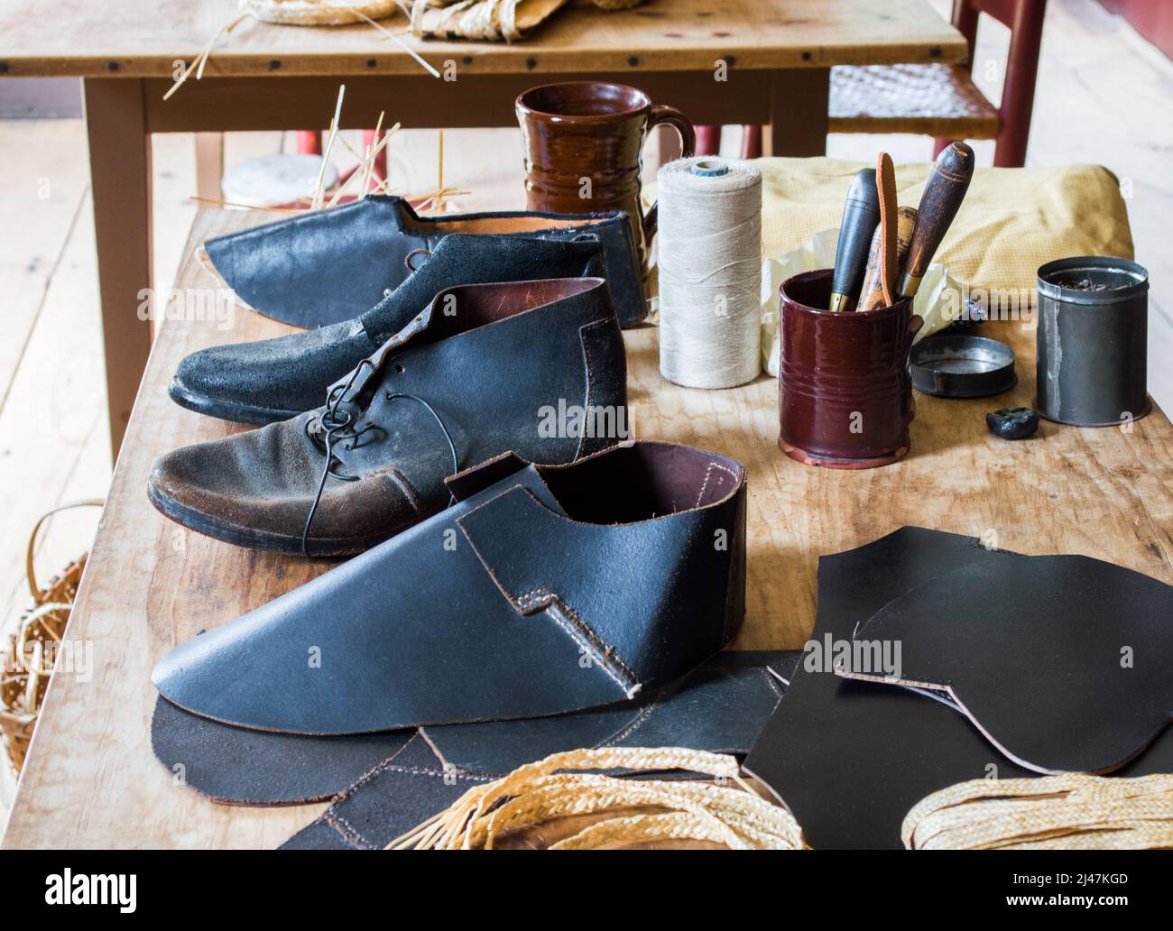 vintage cobbler's work table with colonial leather shoes in progress at Sturbridge Village Massachusetts USA Stock Photo