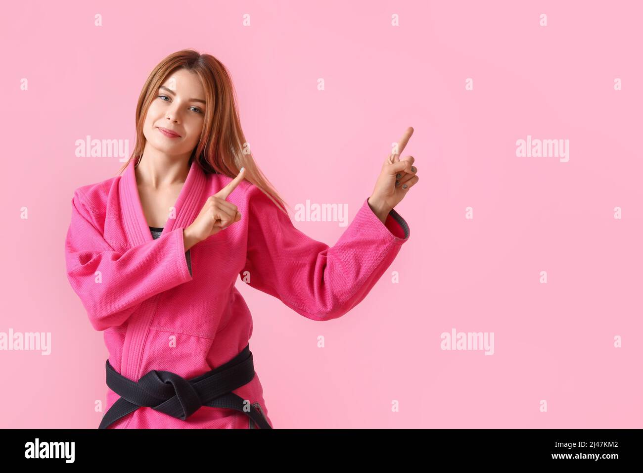 Female karate instructor pointing at something on color background