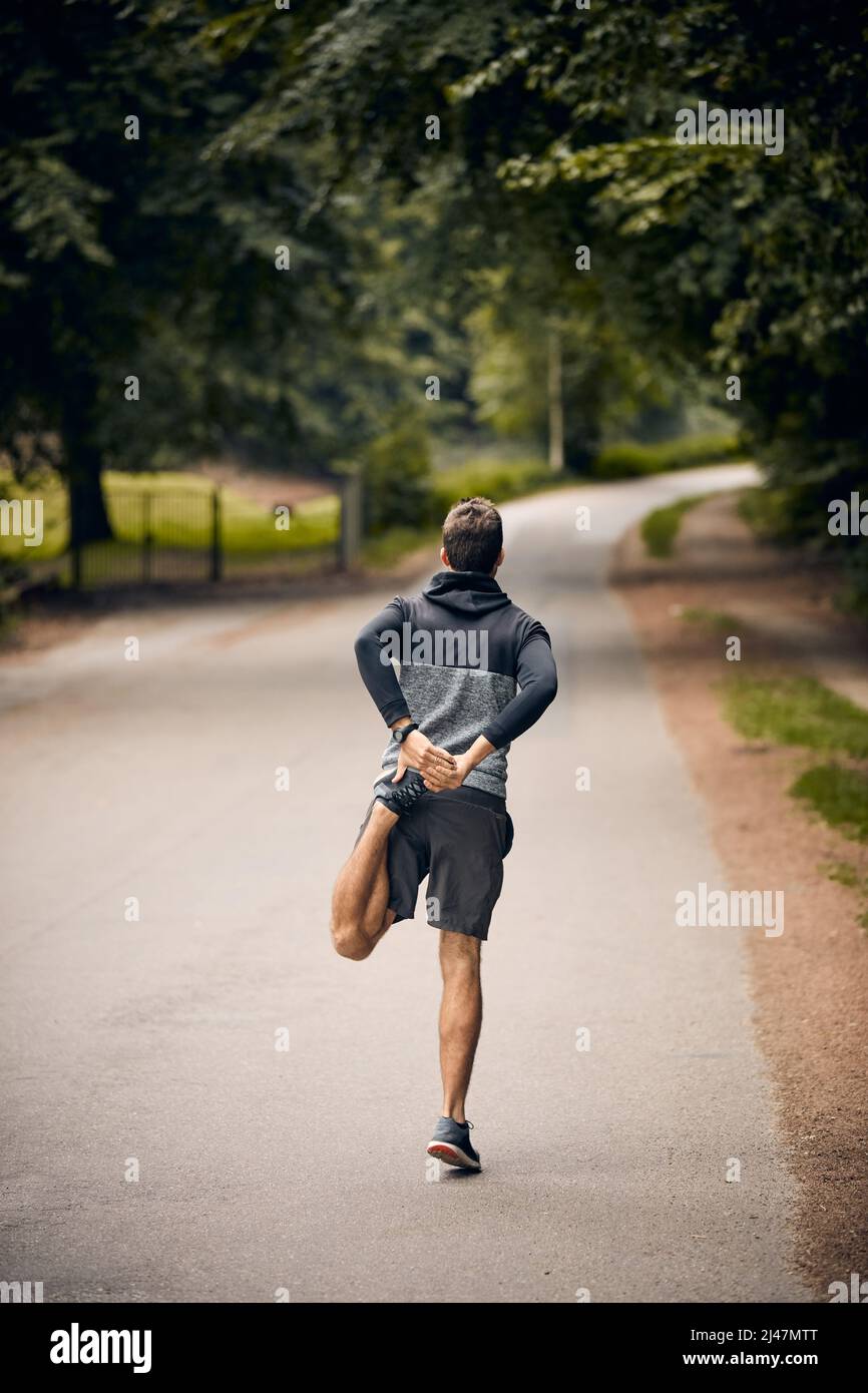 Get in shape. Shot of a sporty man starting his exercise routine with stretching exercises. Stock Photo