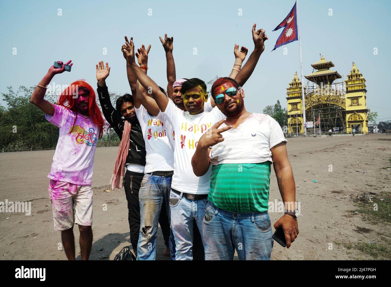 Young spray-painted young men during the Holi festival in the border town of Birgunj, Nepal. In the background the Gate of Nepal. Stock Photo