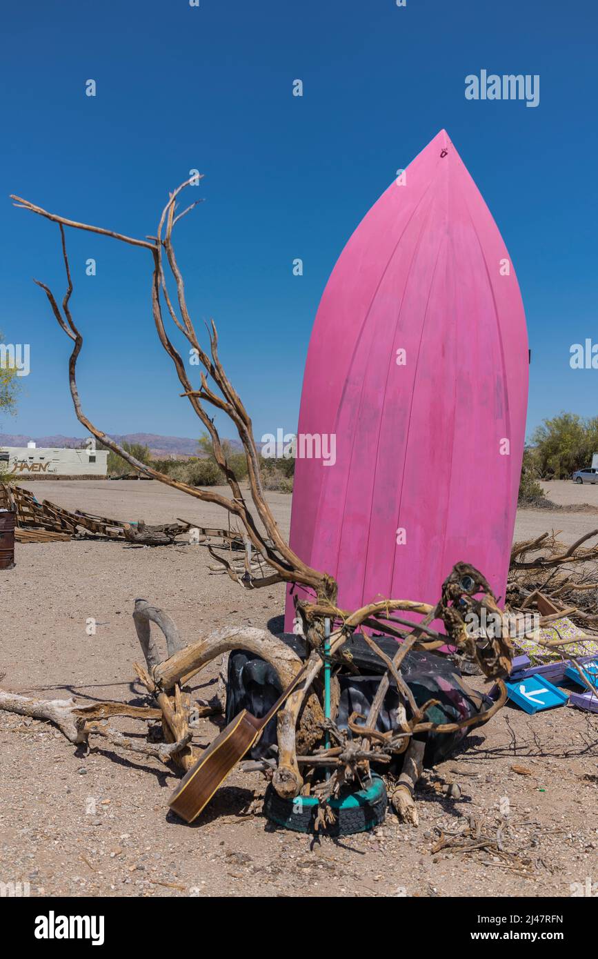 Pink boat hull sitting vertically in the desert in the off-the-grid settlement of Slab City in Southern California. Stock Photo