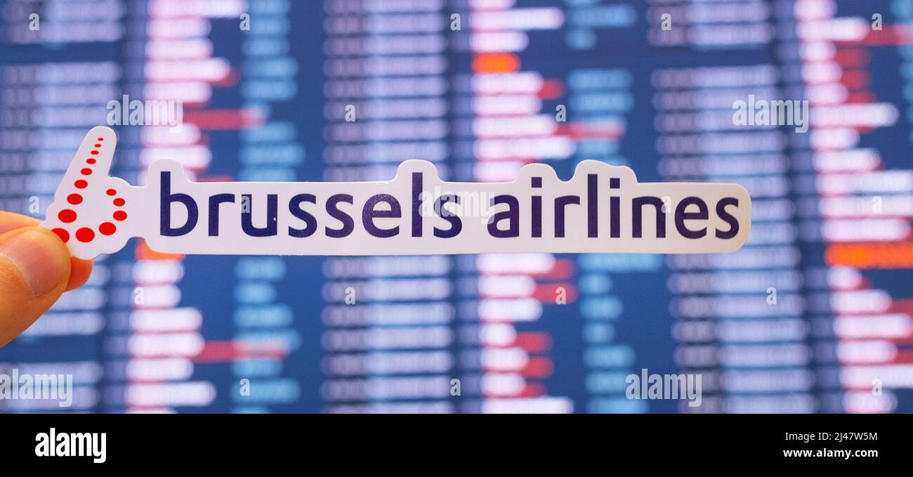 December 11, 2021, Brussels, Belgium. The emblem of Brussels Airlines against the background of an electronic scoreboard with flight schedules at the Stock Photo