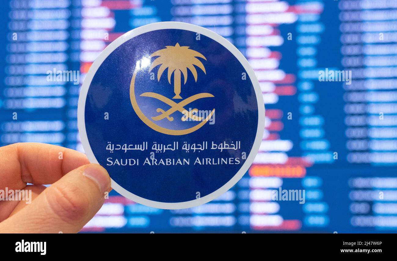 December 11, 2021, Jeddah, Saudi Arabia. The emblem of Saudi Arabian Airlines against the background of an electronic board with a flight schedule at Stock Photo