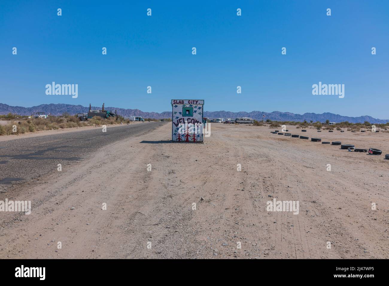 A tiny building with a mural painted on it welcoming visitors to Slab City. It is an off-the-grid community with no municipal services. It gets it nam Stock Photo