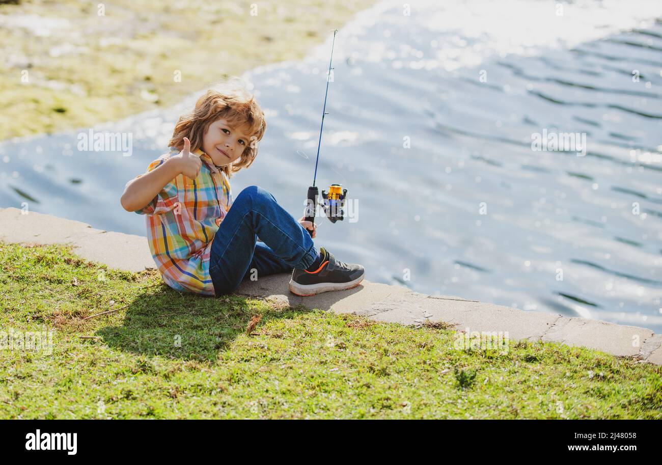 Happy childhood. Child fishing on the lake. Boy with spinner at river