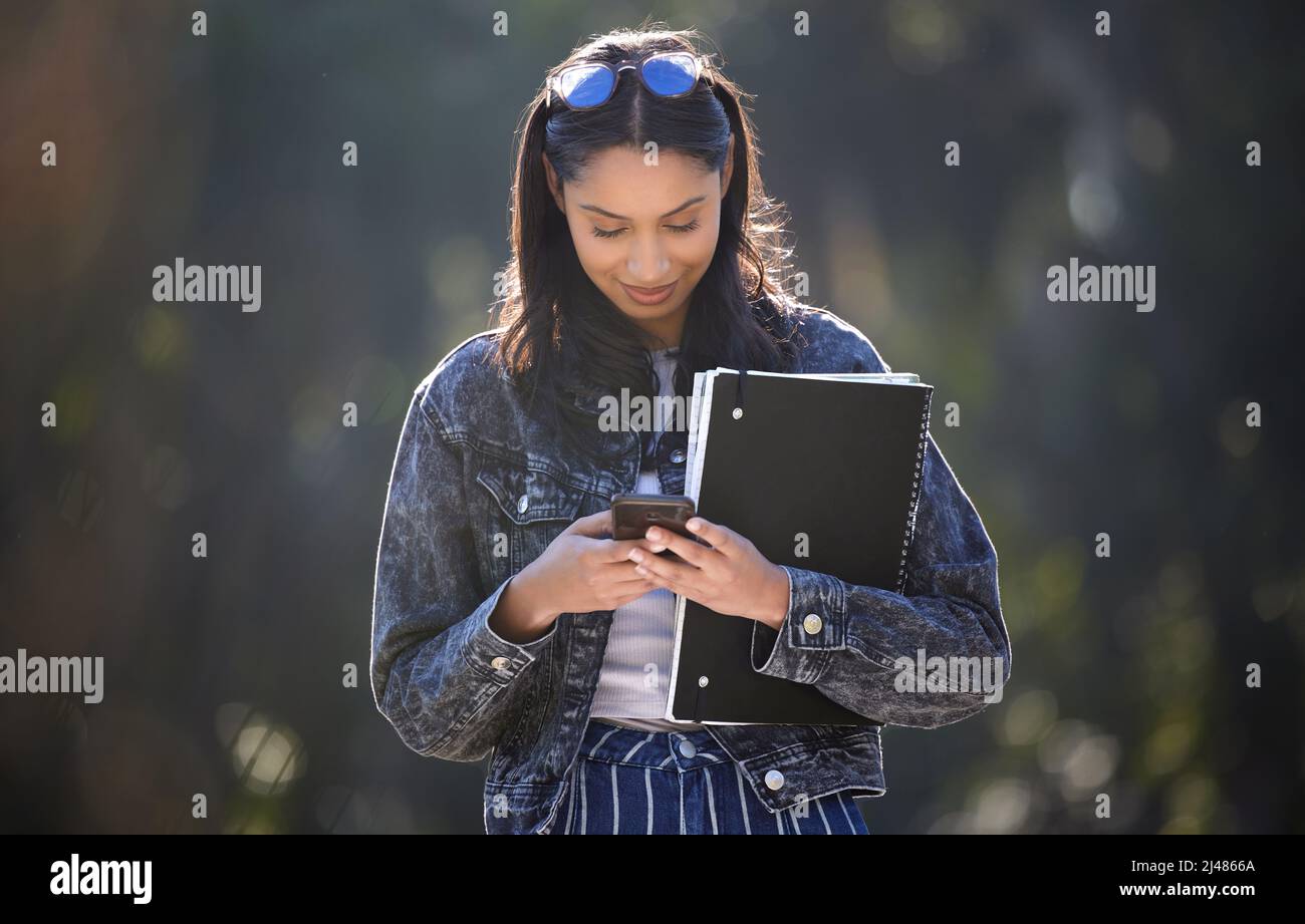I hate waiting alone. Shot of an attractive young female student standing outside on campus. Stock Photo