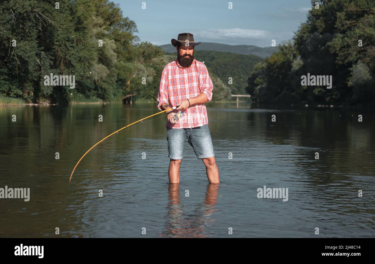 Man fisherman catches a fish. Fly fishing. Brown trout being caught in ...