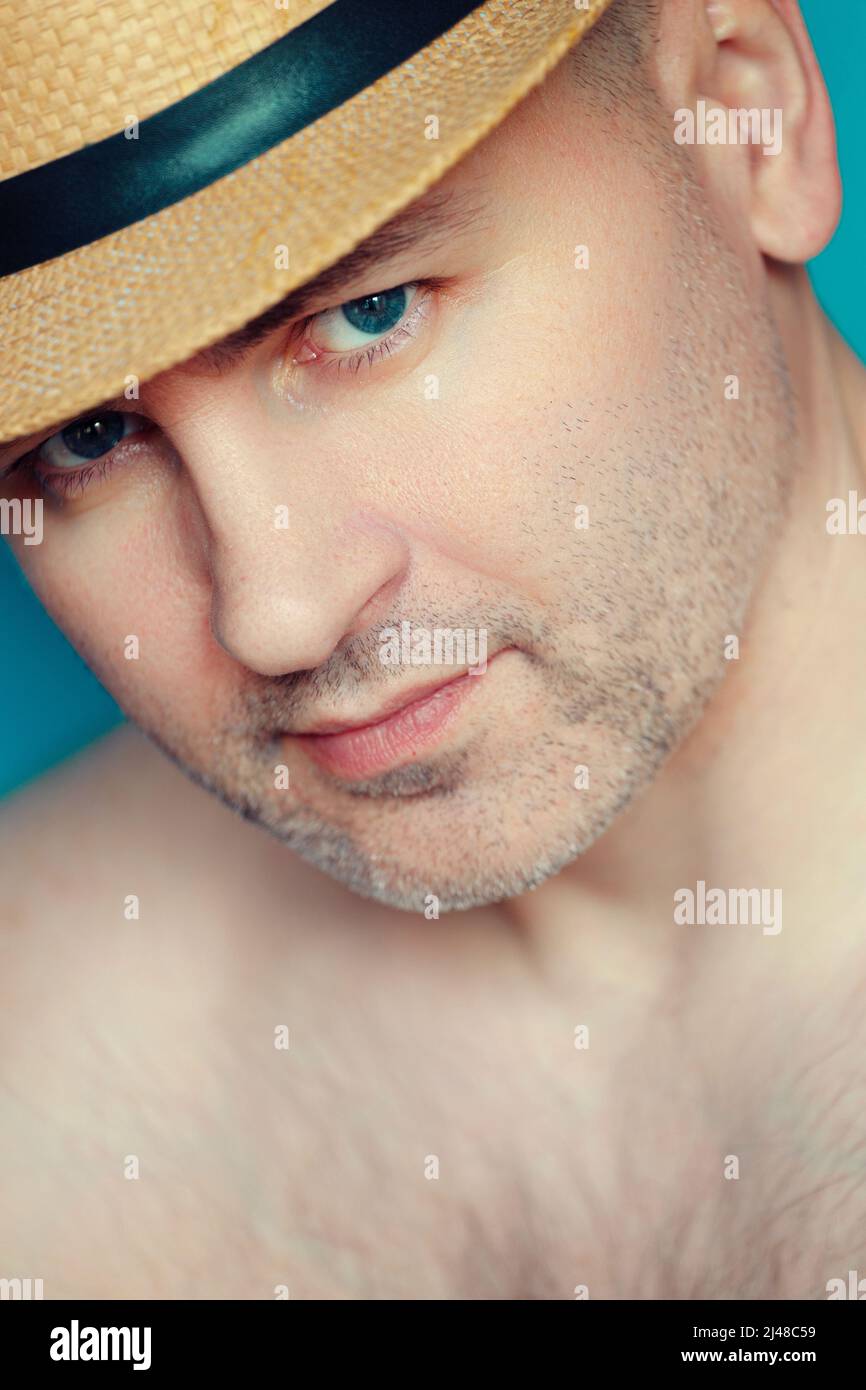 Portrait of white Caucasian man 40-45 years old in hat and bare chest. Seducer and ladies' pleaser. Look from under hat. Man's face with slight unshavenness Stock Photo