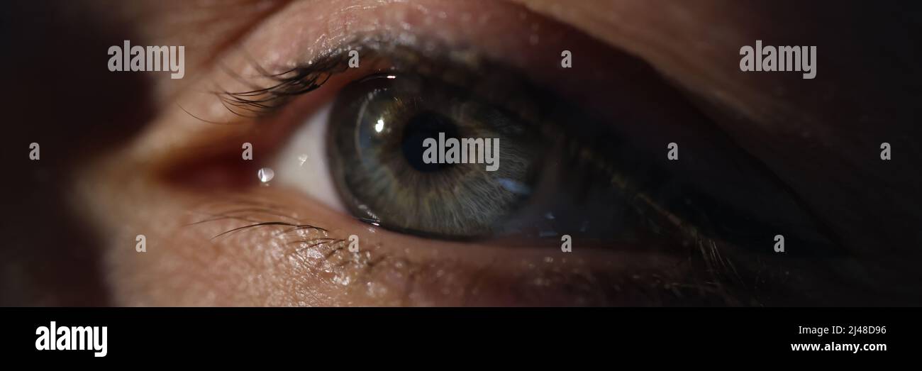 Closeup of woman green eye in dark Stock Photo