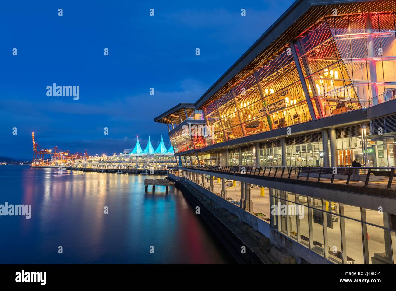 Night scene of modern buildings in Vancouver downtown. Long exposure of Canada Place. Colorful city night with waterfront park. Street photo, selectiv Stock Photo