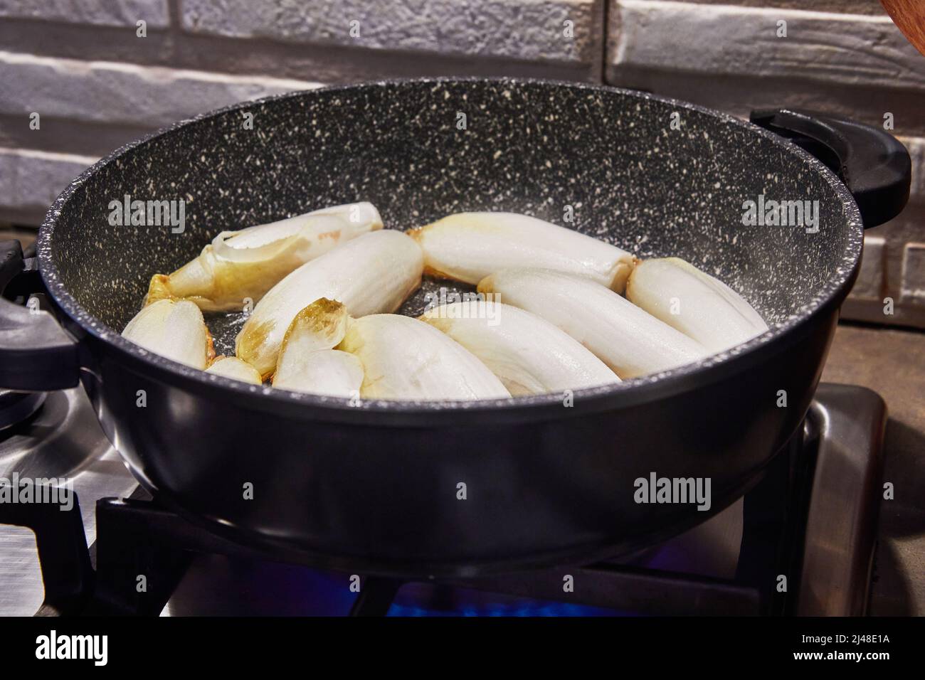 Chicory stew in pan on gas stove according to recipe from the